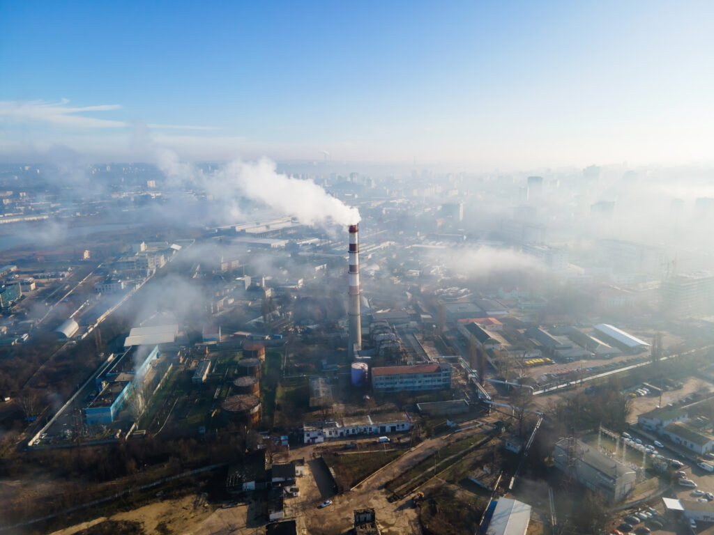 Aerial drone view of Chisinau. Thermal station with smoke coming out of the tube. Buildings and roads. Fog in the air